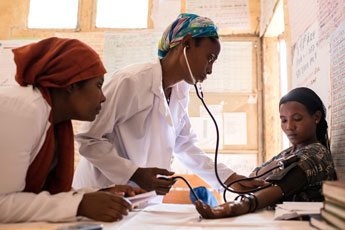Group of medical staff listen to a colleague during a meeting.